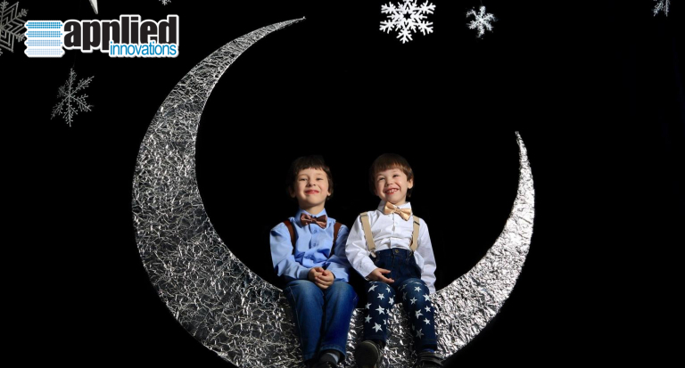 twins sitting on a moon cutout